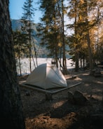 A cozy camping tent in a serene forest setting.