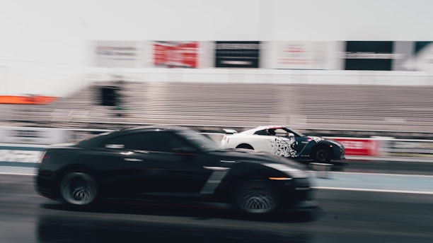 a black car driving down a race track