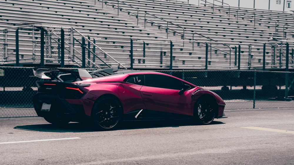 a red sports car parked in front of a bleachers