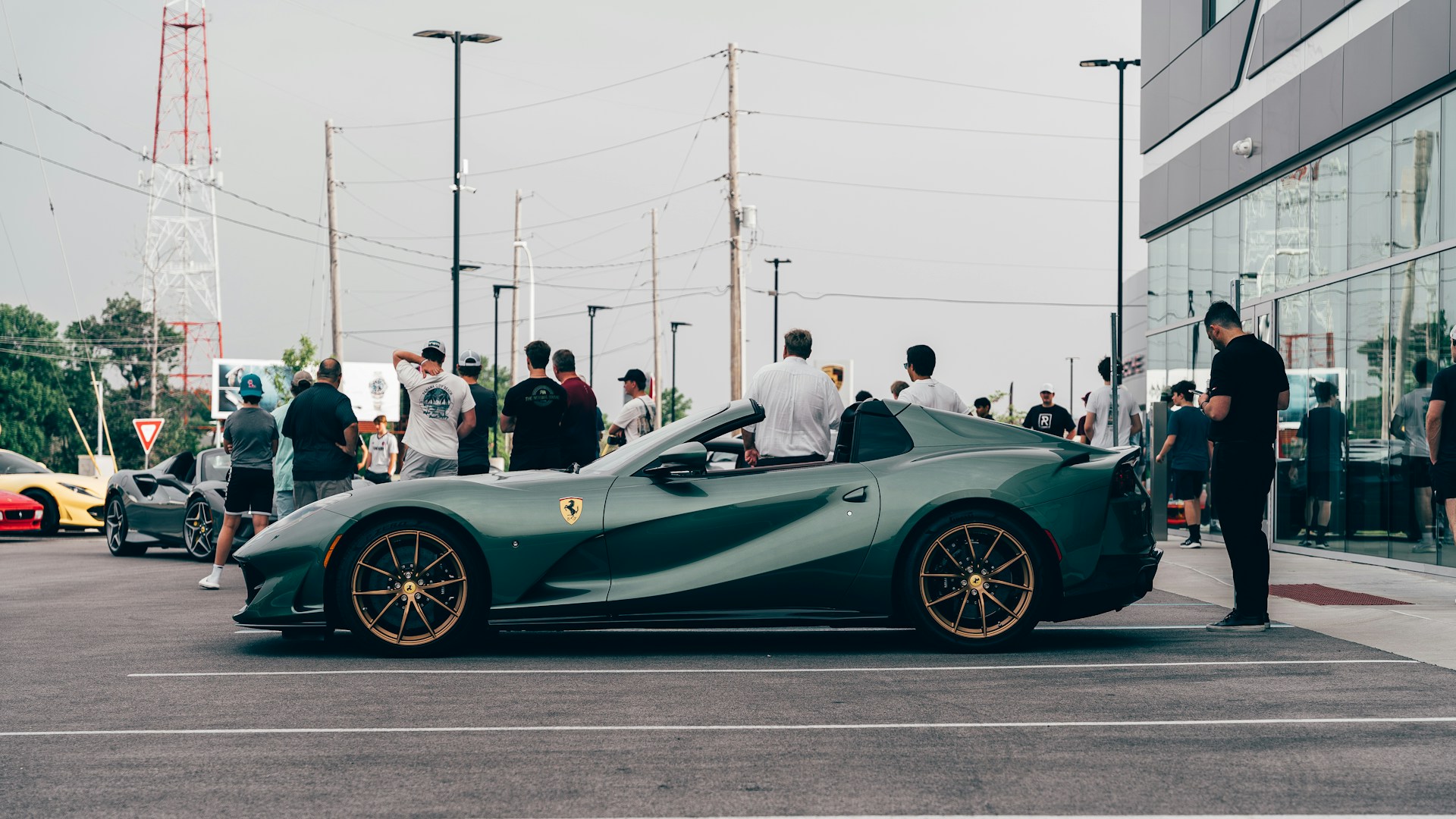 a group of people standing around a green sports car