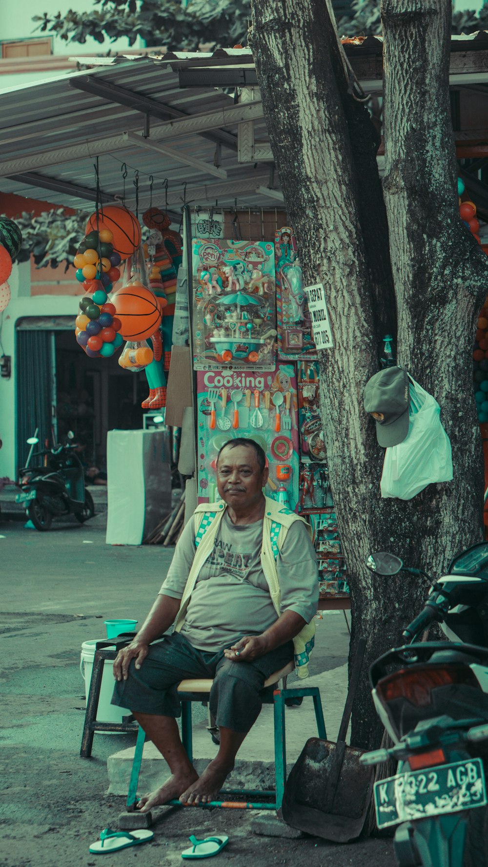 a man sitting on a chair in front of a tree