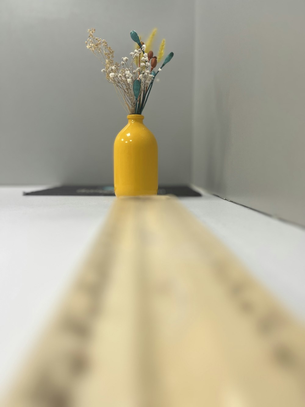 a yellow vase with some flowers in it