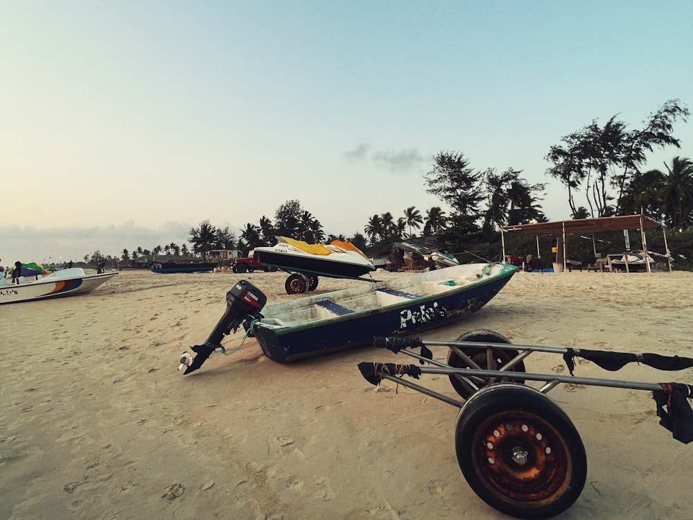 a couple of boats sitting on top of a sandy beach