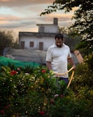 A technician adjusting irrigation equipment in a lush home garden.