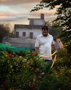 A person watering a vibrant garden with various flowering plants