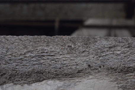Close-up of freshly brushed concrete slab with visible texture in an industrial yard.