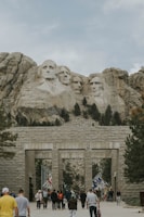 a group of people walking in front of a mountain