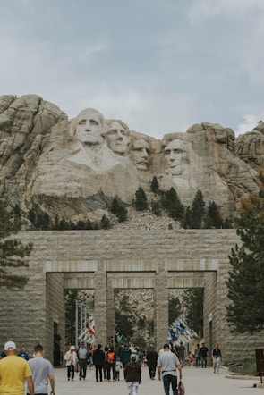a group of people walking in front of a mountain
