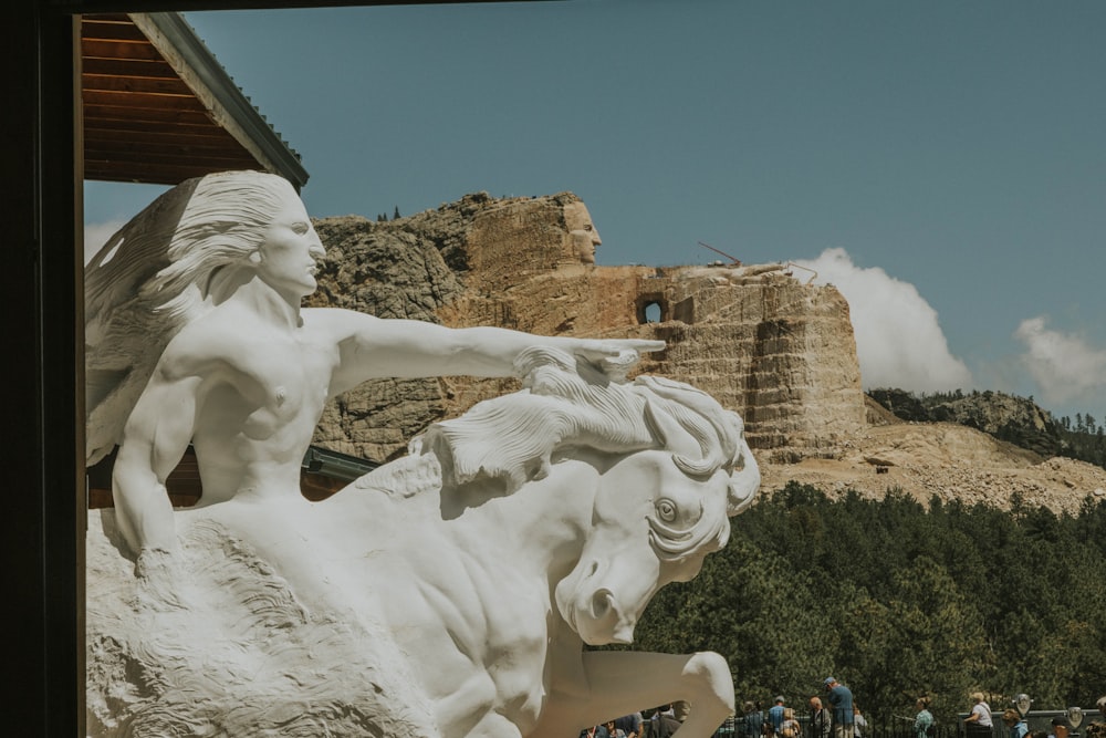 a statue of a woman riding a white horse