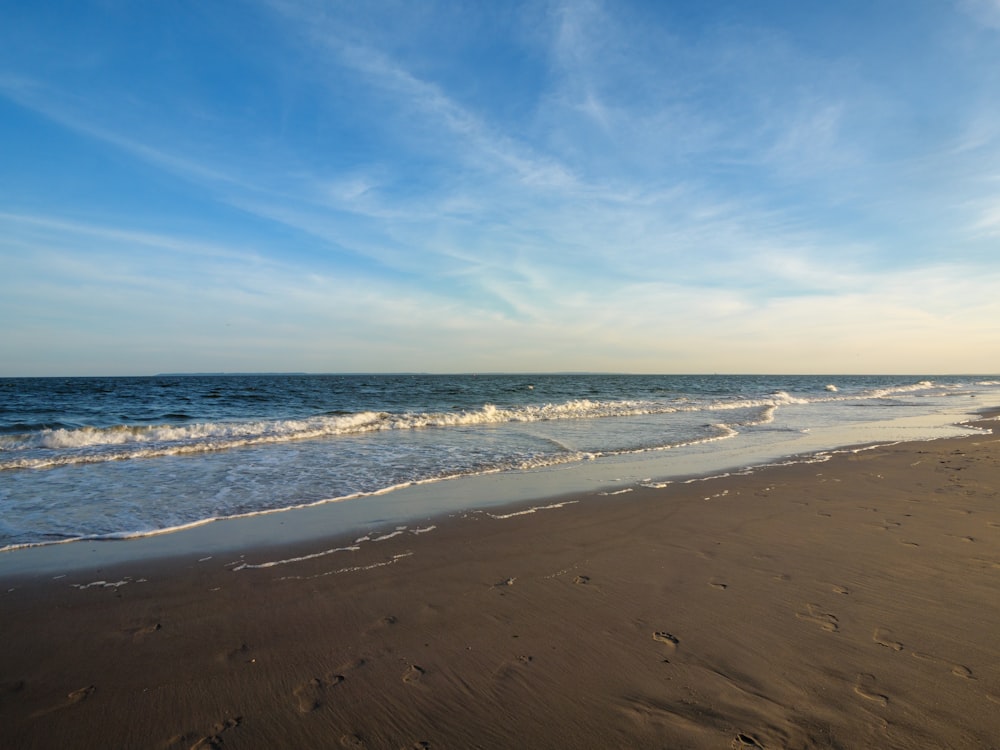 a sandy beach with waves coming in to shore