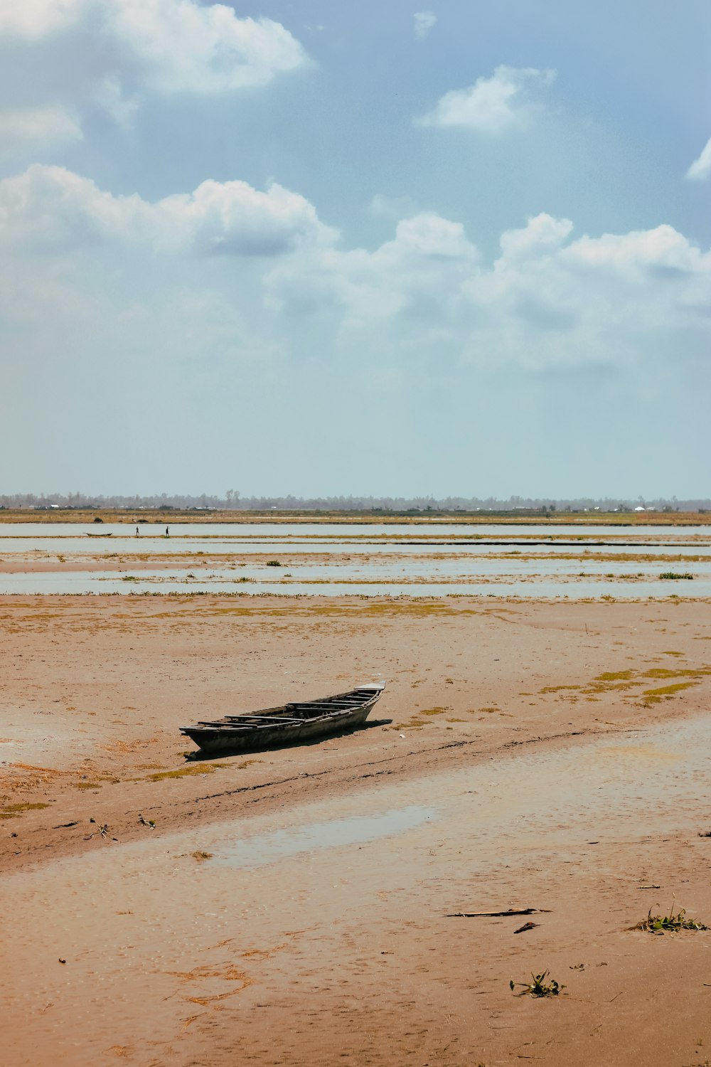 a boat sitting on top of a sandy beach