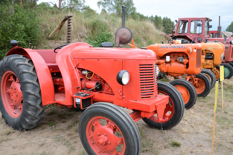 A vibrant display of agricultural machinery lined up in a sunlit field, ready for work.