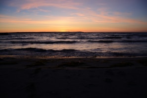 A peaceful beach scene at sunset, capturing the slow living vibe of the town.