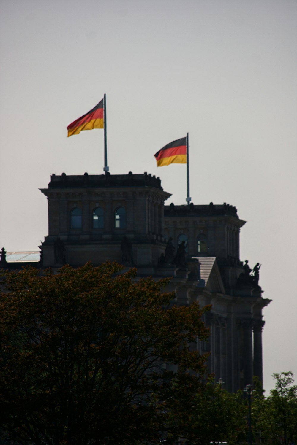 two flags flying on top of a building