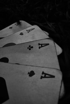 four playing cards are laying on the ground