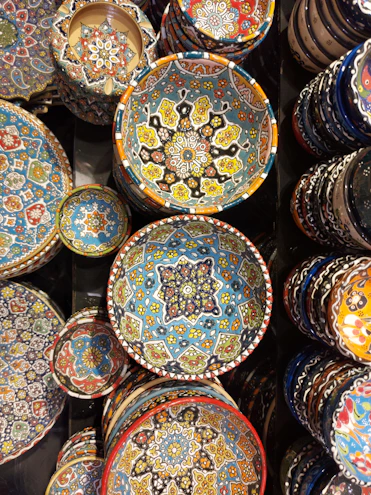 Close-up of vibrant ceramic bowls stacked neatly, showcasing their hand-thrown texture and colorful glaze.