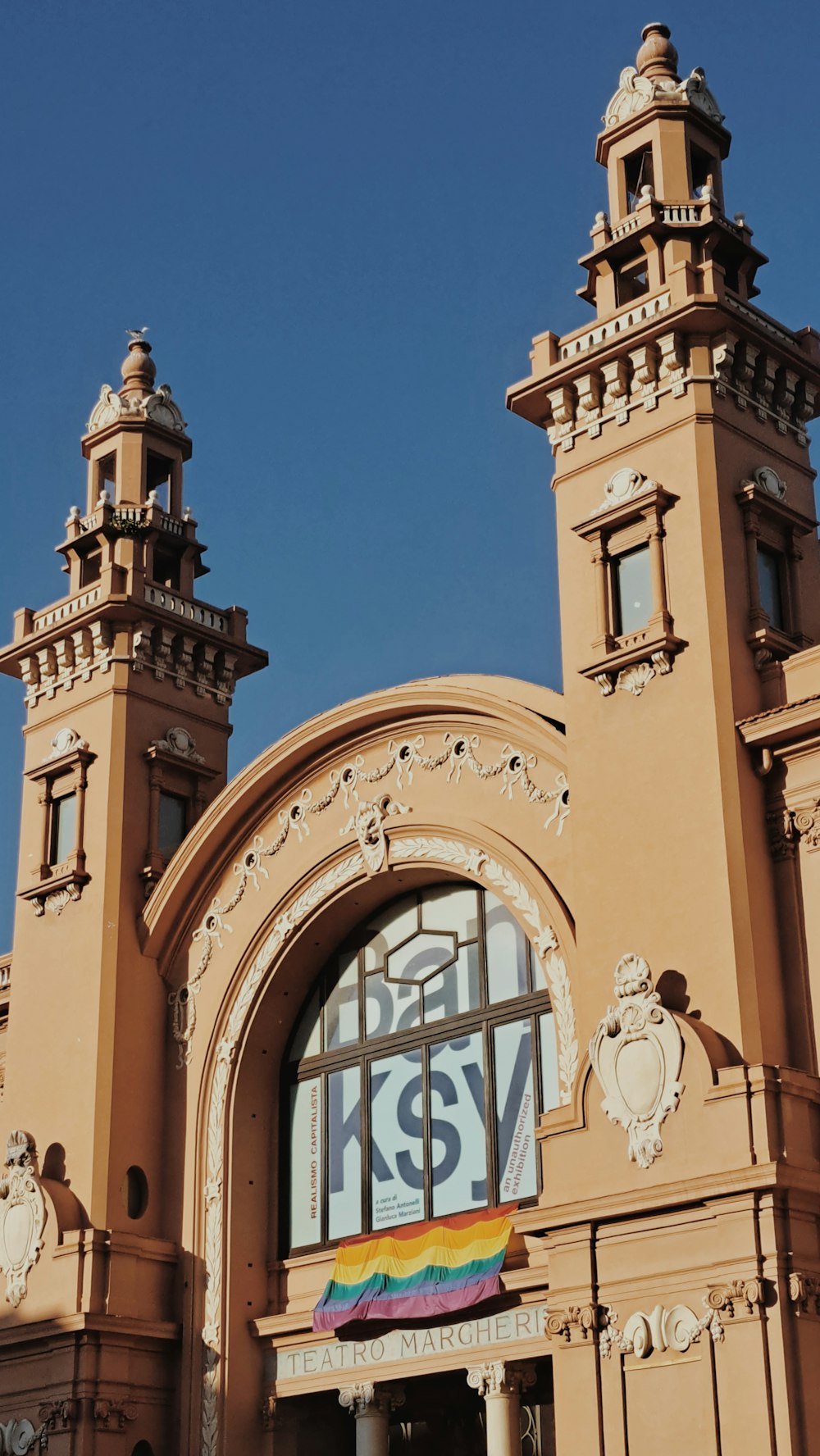 um grande edifício com duas torres e uma bandeira do arco-íris