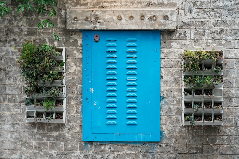 a blue door and window on a brick wall