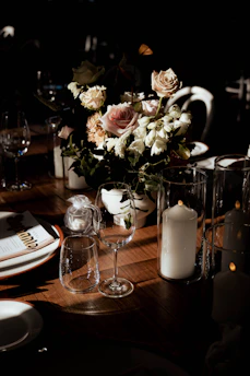 A beautifully arranged banquet table with elegant dishes and floral centerpieces under soft lighting.