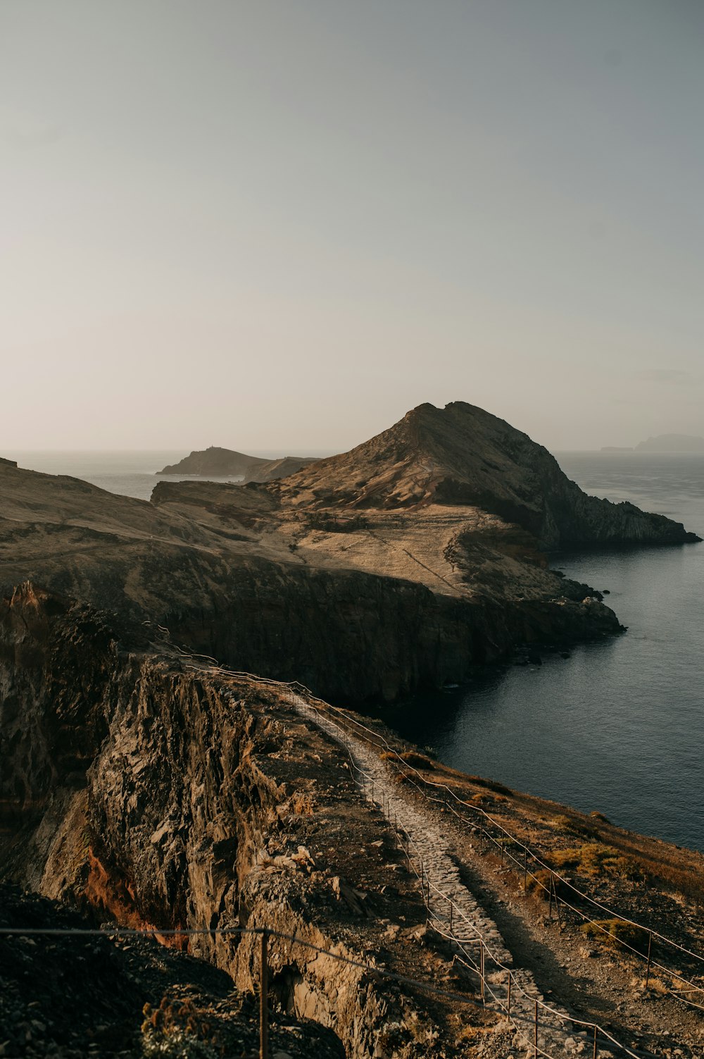 a large body of water sitting next to a rocky cliff