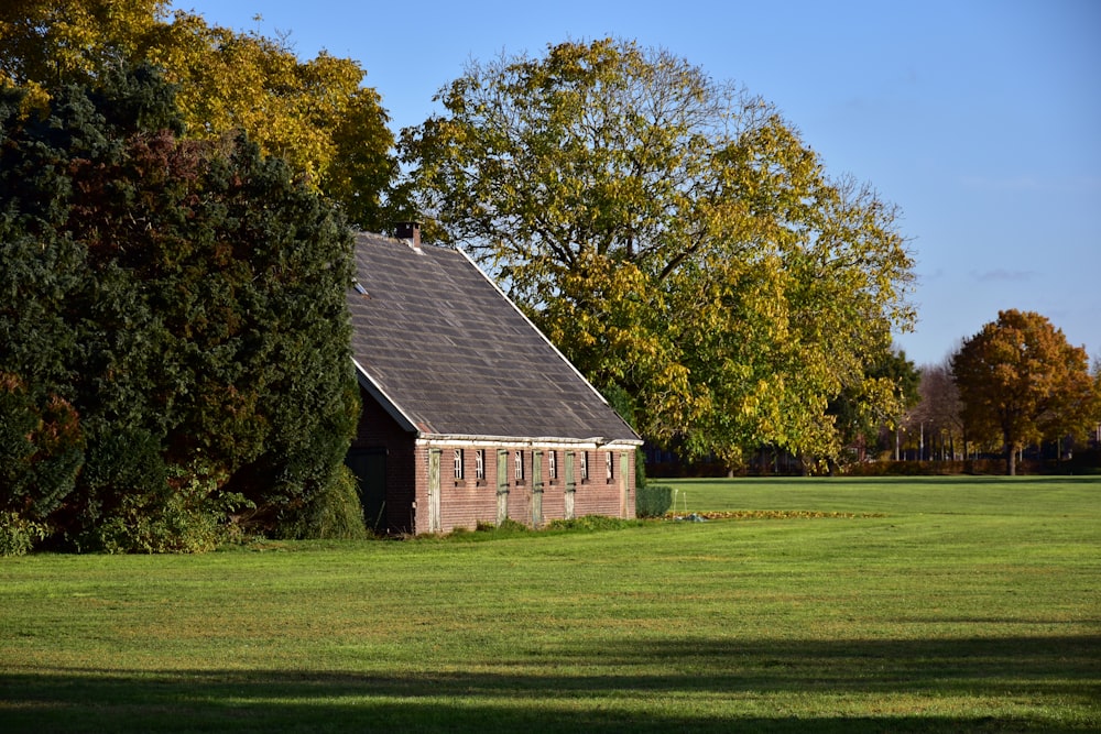 un petit bâtiment assis au milieu d’un champ