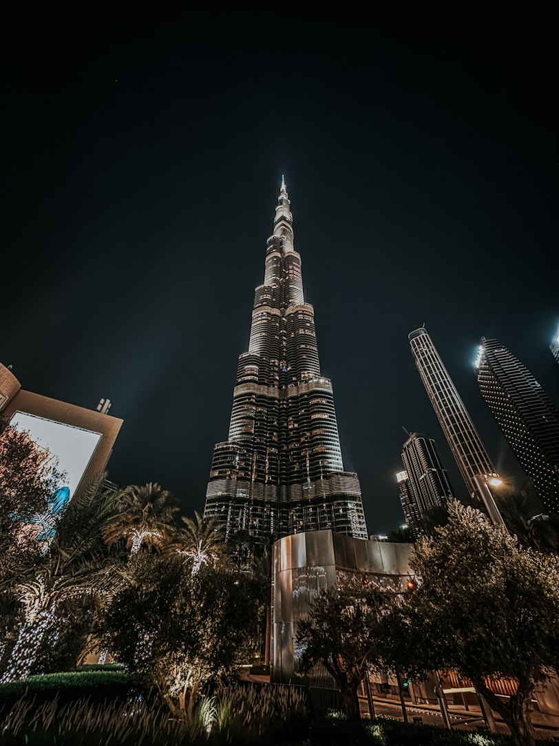 a very tall building towering over a city at night
