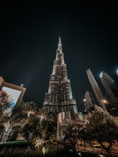 a very tall building towering over a city at night
