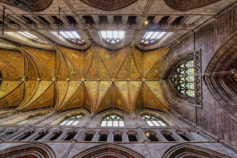 the ceiling of a large cathedral with stained glass windows