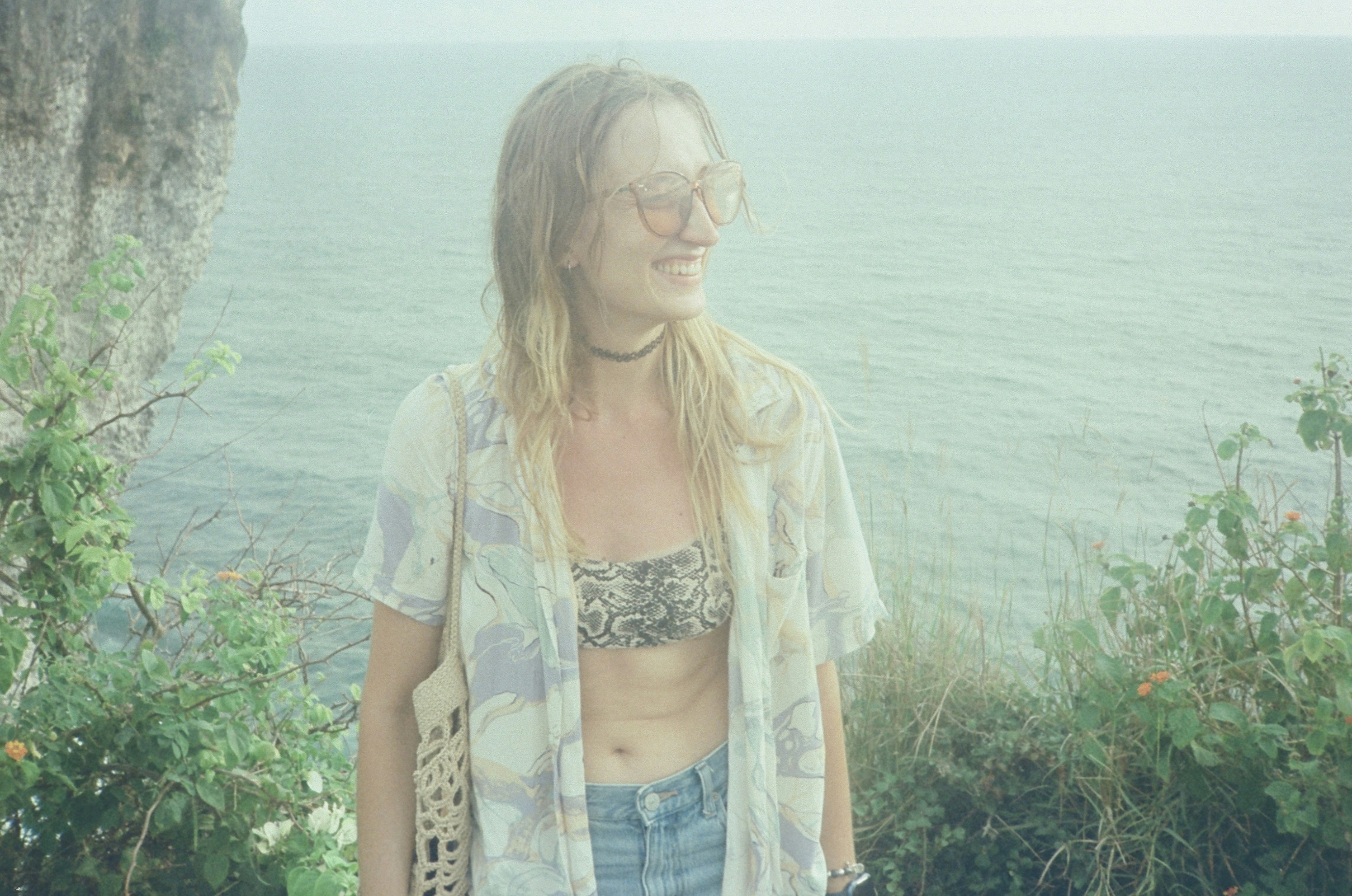 Una donna in piedi sulla cima di una scogliera vicino all'oceano