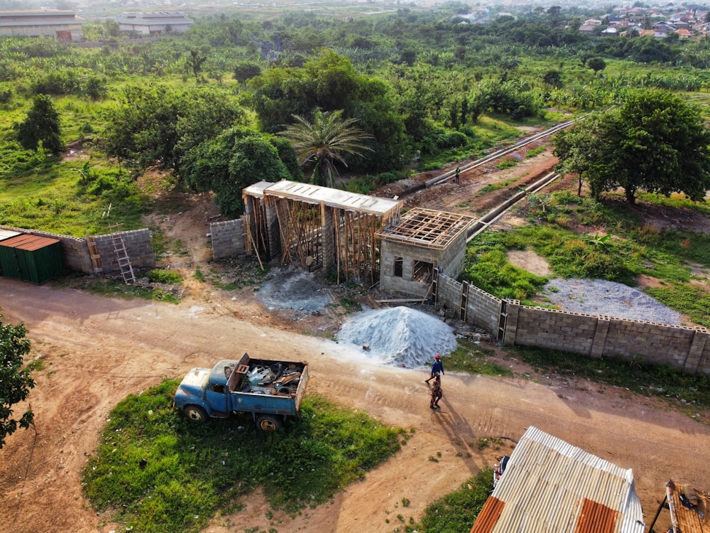 a truck parked next to a building on a dirt road