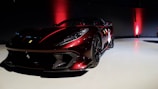A sleek red supercar parked under dramatic lighting showcasing its curves