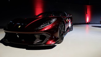 Close-up of a sleek sports car and a motorcycle under dramatic lighting matching the website's dark and red theme.