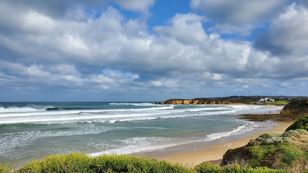 a view of a beach with waves coming in to shore