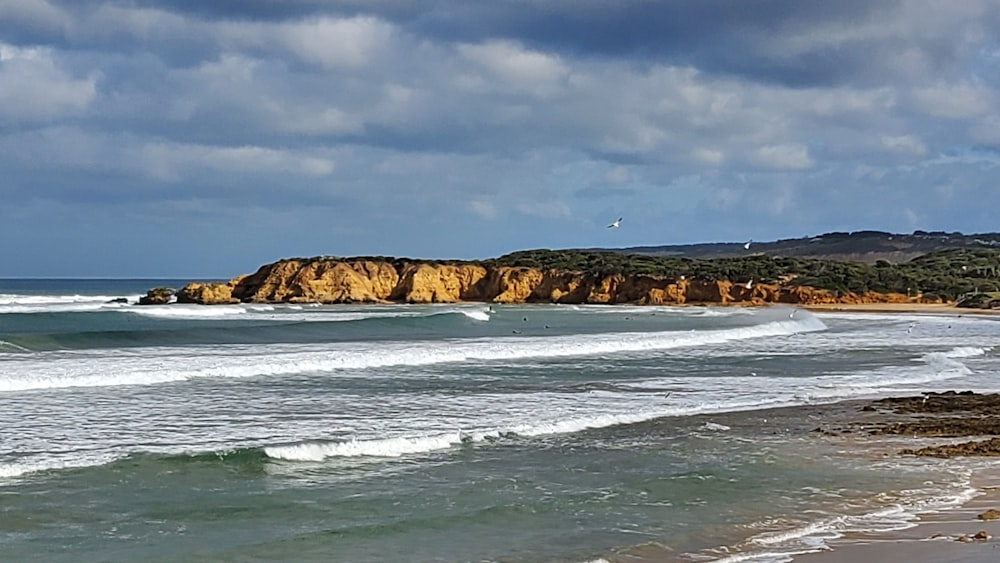 a view of a beach with waves coming in to shore