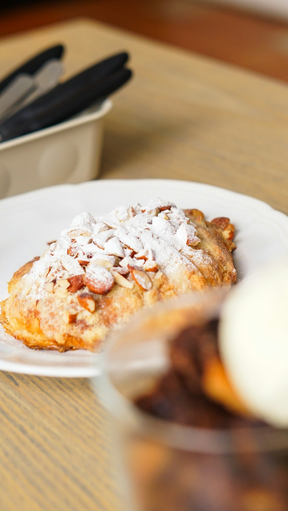 a white plate topped with a pastry covered in powdered sugar