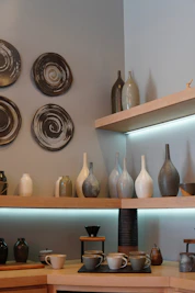 a display of vases and plates on a shelf