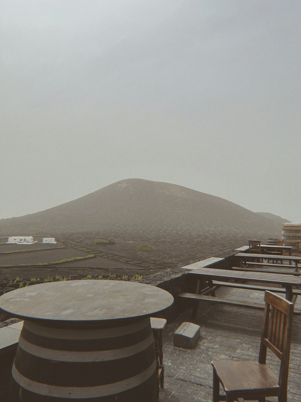 a table and chairs on a roof with a mountain in the background