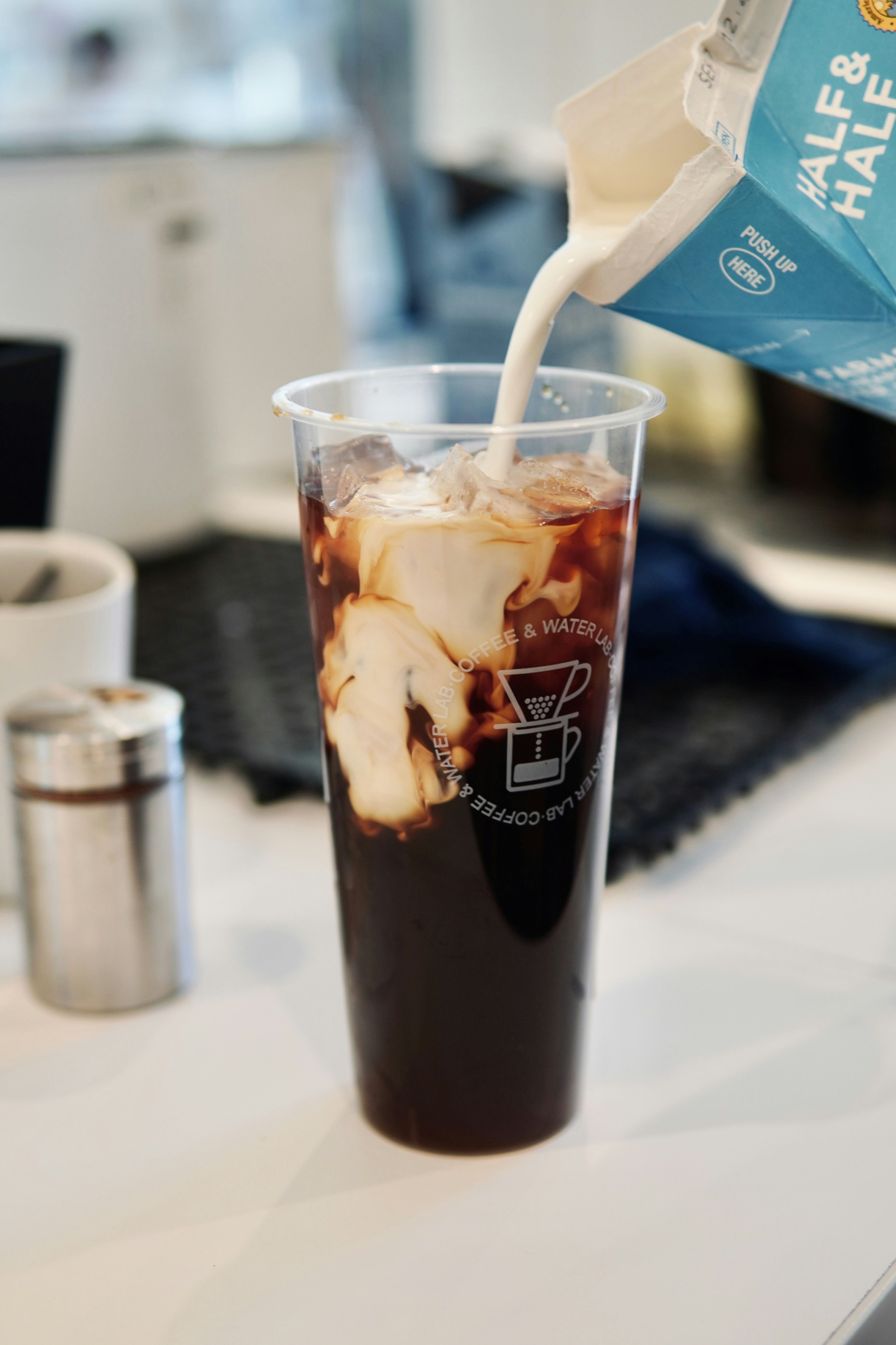 a drink being poured into a plastic cup