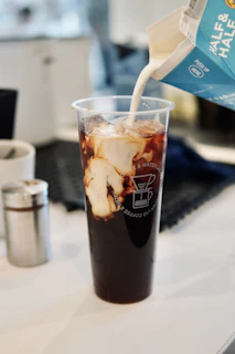 a drink being poured into a plastic cup