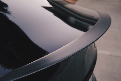 Close-up of a sleek black ABS car spoiler installed on a sporty vehicle