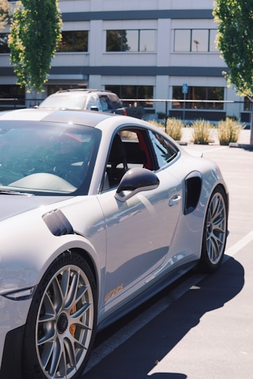 A sleek gray Dolph GS parked beside a modern shopping mall entrance.