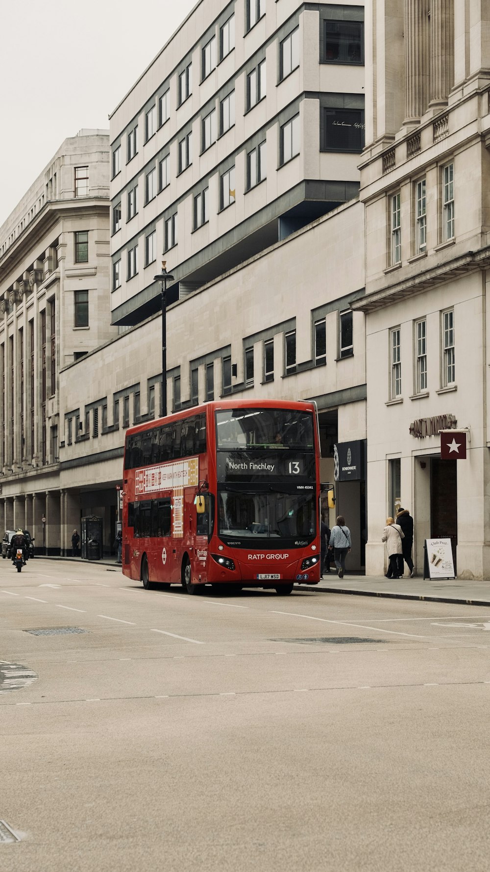 a red double decker bus driving down a street