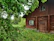 A cozy wooden cabin surrounded by lush green trees and blooming spring flowers at Ranch Amanda.