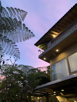 Wide angle of a completed residential exterior with landscaping and twilight skies.