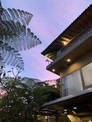 Photorealistic 3D exterior render of a modern villa glowing under twilight.