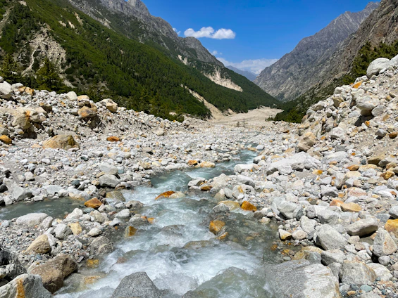 A clear river flowing through a Baja California landscape with mountains in the background.