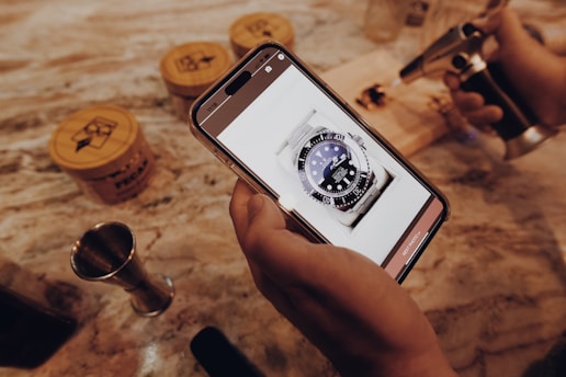 a person holding a cell phone with a watch on it