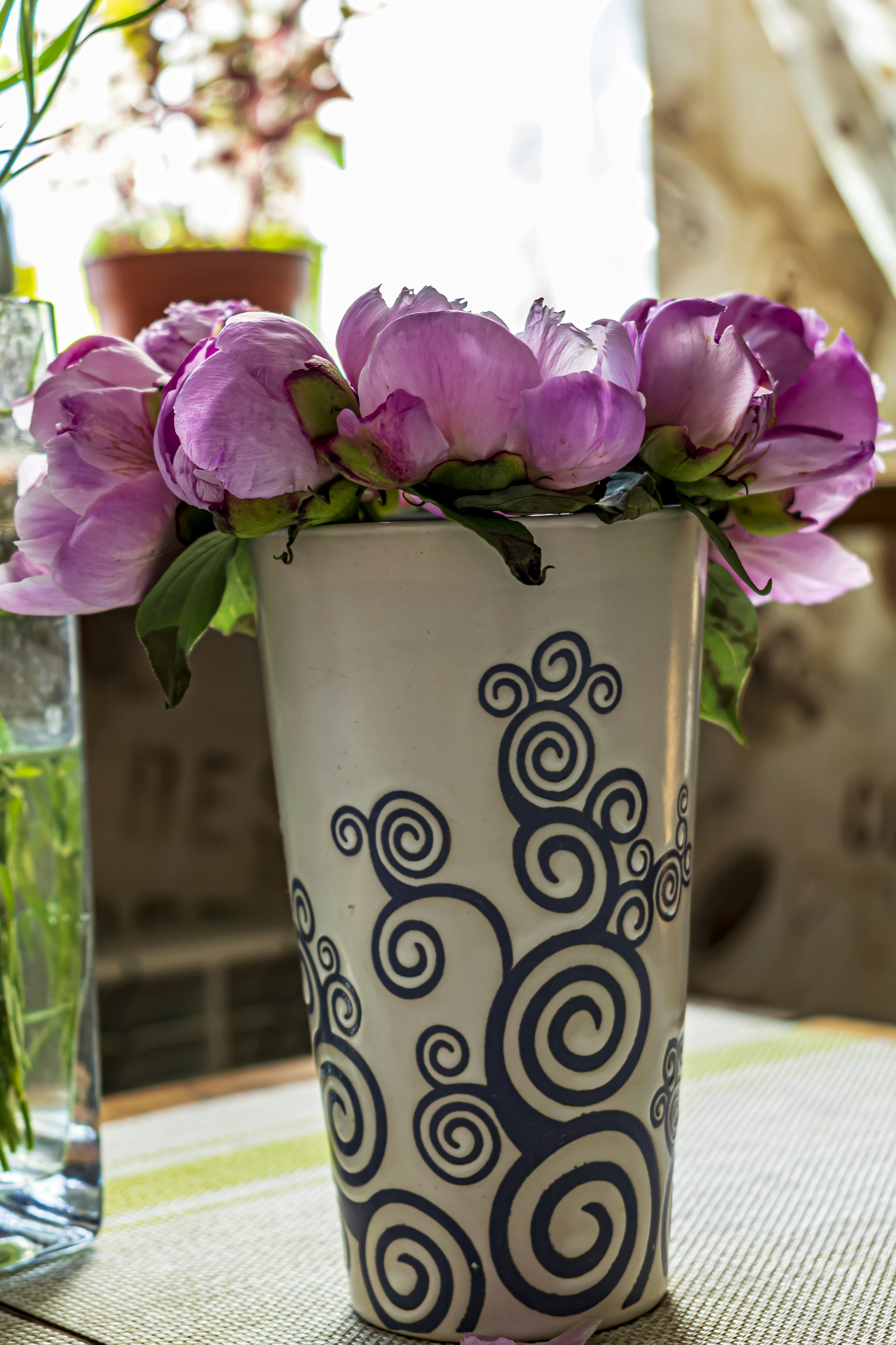 eine Vase gefüllt mit lila Blumen, die auf einem Tisch sitzt