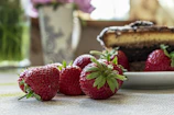 Healthy microwave chocolate mug cake garnished with fresh strawberries on a cozy table.