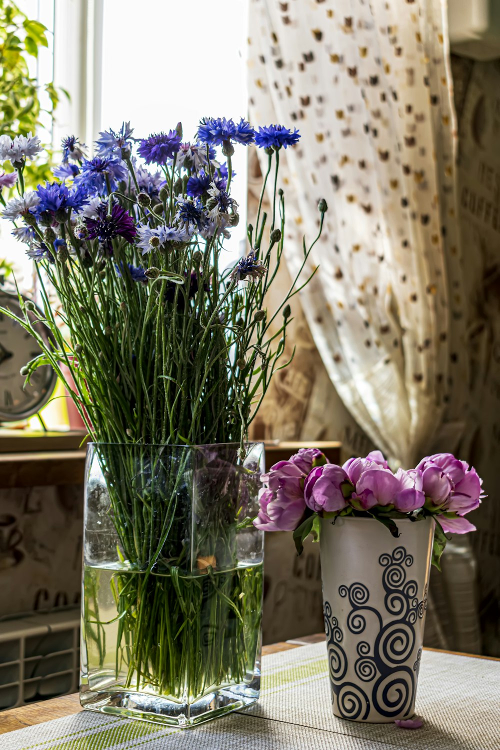 a couple of vases filled with flowers on a table